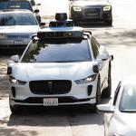 A futuristic robotaxi with sleek design driving on an urban road, symbolizing advancements in autonomous vehicle technology and efforts to gain passenger trust."