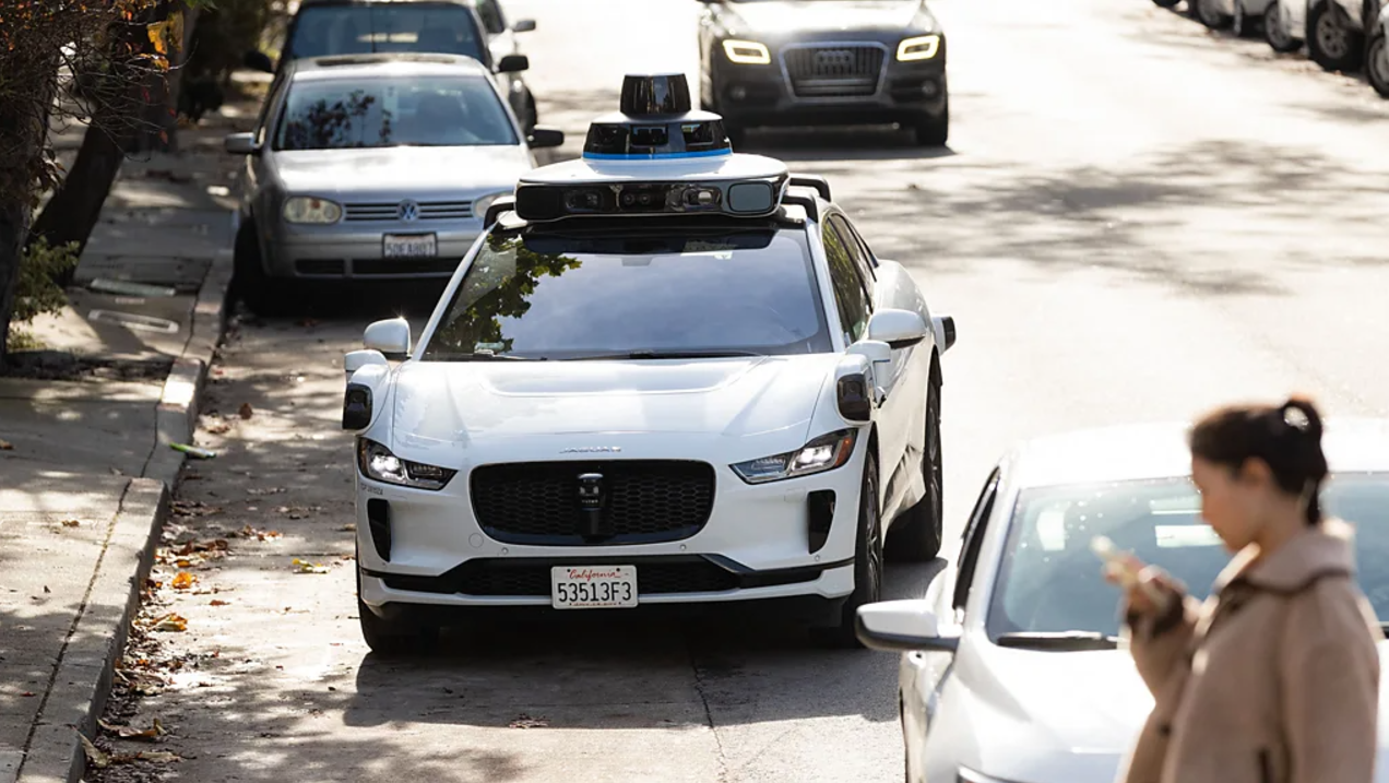 A futuristic robotaxi with sleek design driving on an urban road, symbolizing advancements in autonomous vehicle technology and efforts to gain passenger trust."